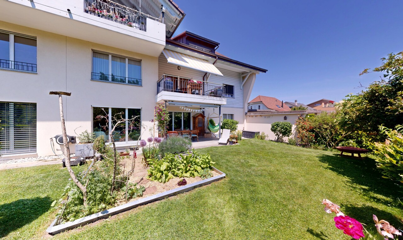 façade avec balcon, terrasse, bardage en stuc, pelouse, et day time