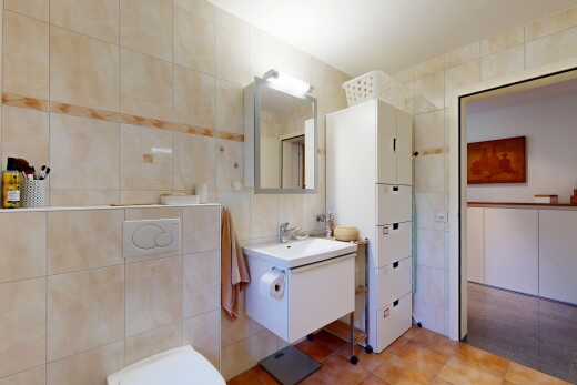 salle de bains avec mur en carrelage, tile wall, lavabo (ou coiffeuse selon le contexte), miroir, et inside property