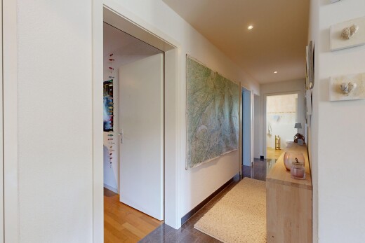 couloir avec inside community, wood finish floor, sol en finition bois, drywall, et cloison sèche