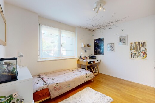 chambre avec cloison sèche, drywall, sol en finition bois, wood finish floor, et lumière naturelle