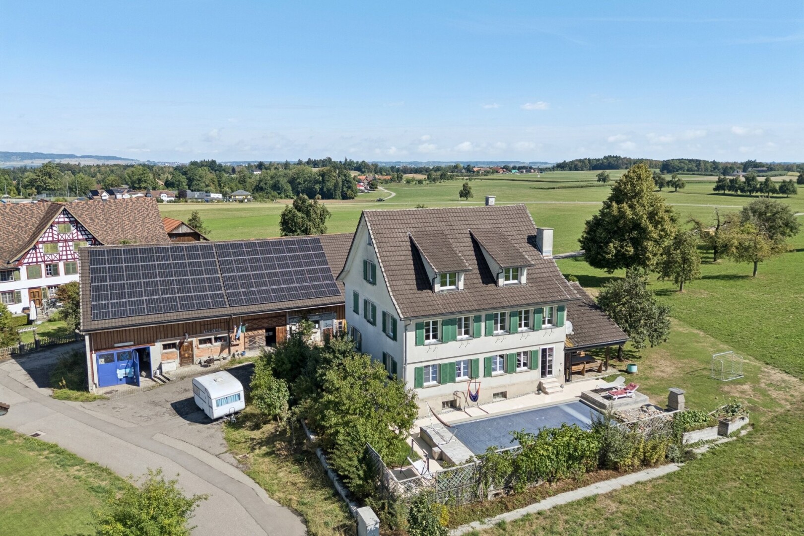 außenansicht mit dachgaube, solaranlage, day time, property visible, und drone view
