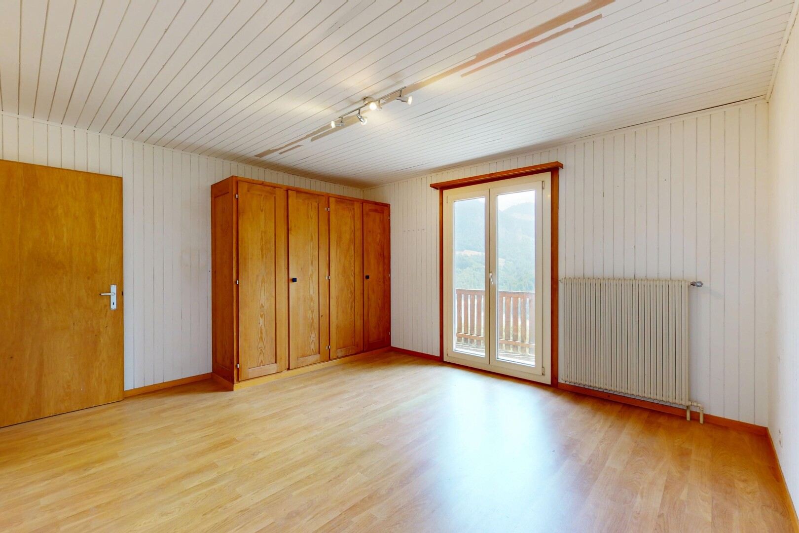 chambre avec accès à l'extérieur, radiateur, lumière naturelle, natural light, et sol en finition bois