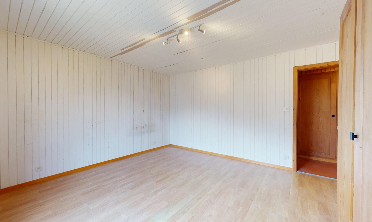 pièce vide avec wood finish floor, sol en finition bois, inside property, track lighting, et éclairage sur rail