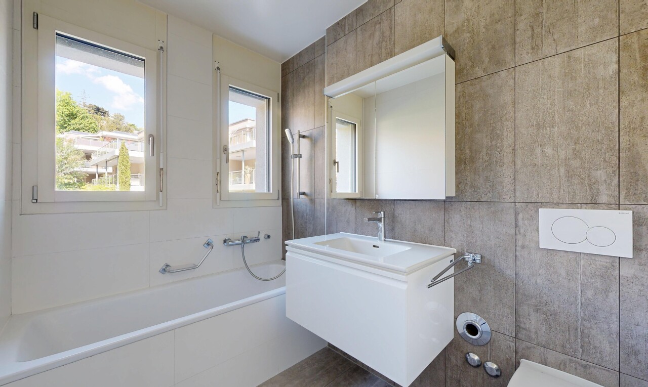 bathroom with tile walls, a garden tub, and vanity