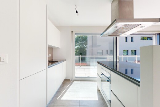 cuisine avec dark countertops, flat panel cabinets, armoires à panneau plat, hotte, et white cabinets
