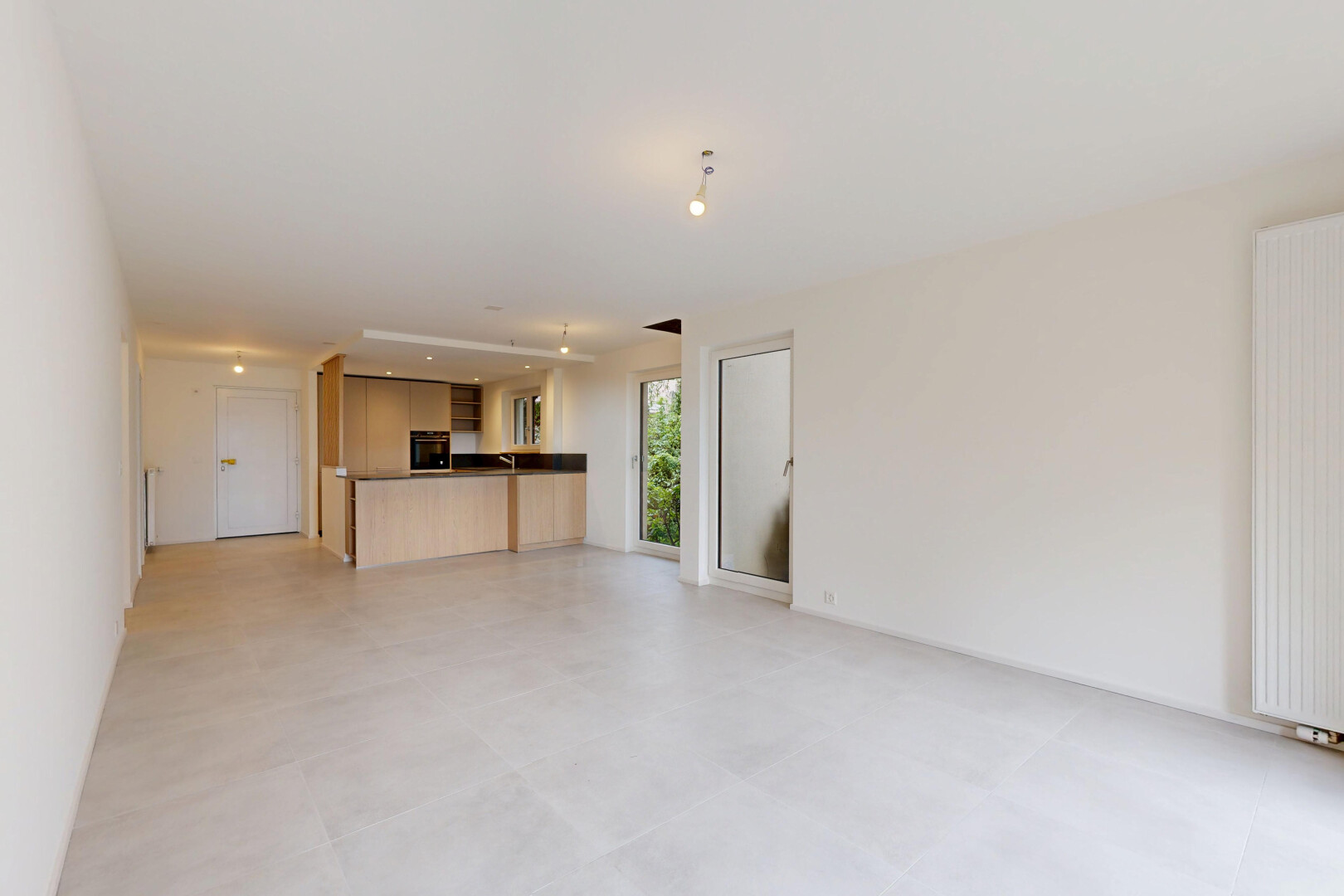 pièce vide avec drywall, cloison sèche, inside property, light floor, et radiateur