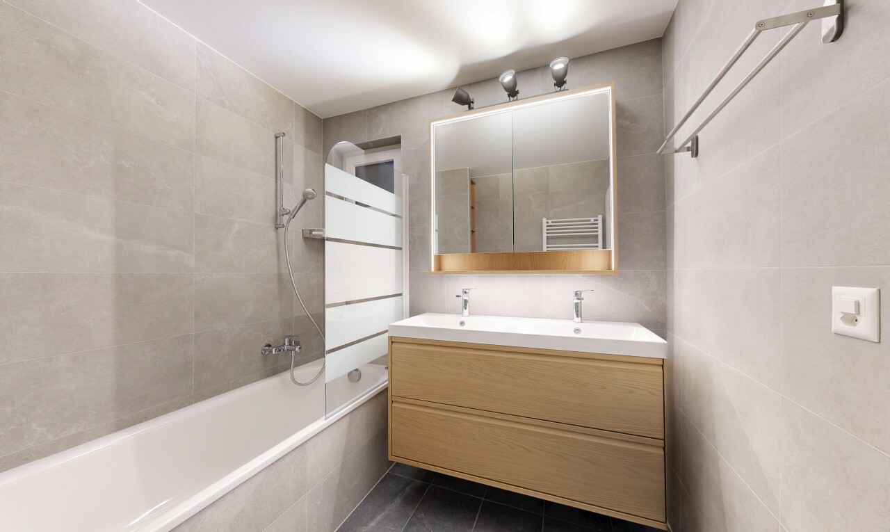 salle de bains avec tile wall, mur en carrelage, miroir, salle de bain complète, et double vasque
