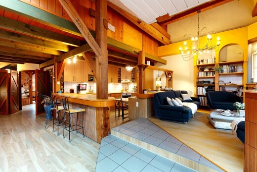 wohn- / esszimmer mit bemerkenswerter kronleuchter, inside property, balkendecke, beamed ceiling, und holzfußboden