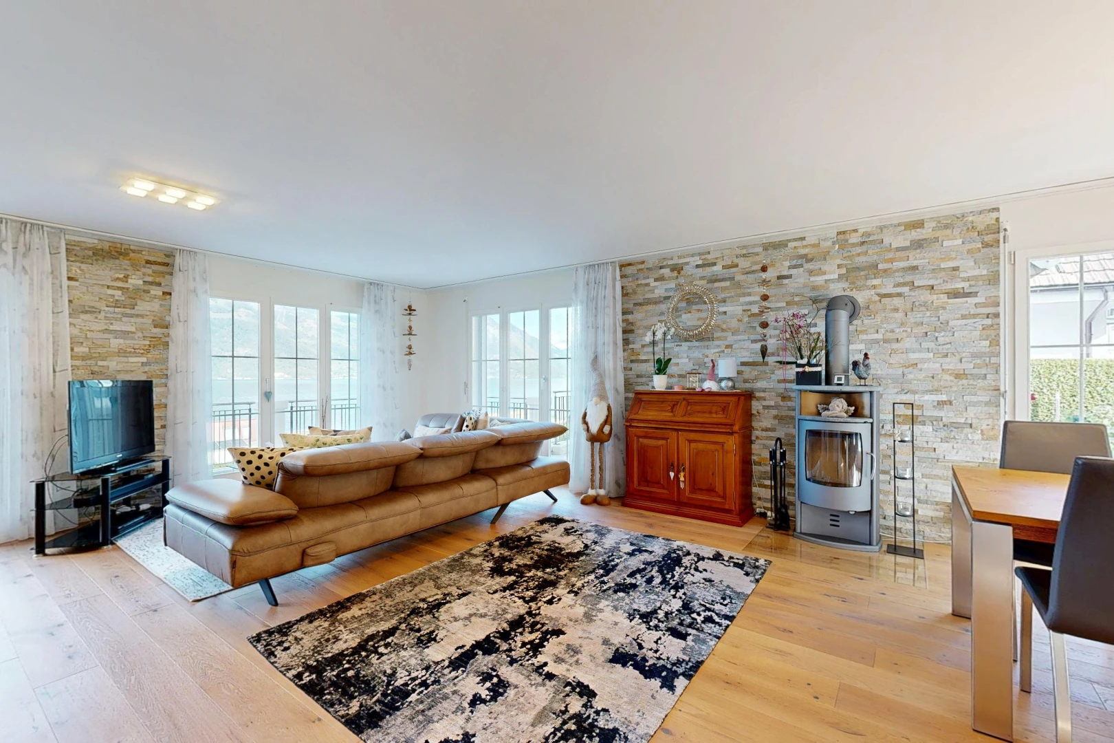 living area with a wood stove, light wood finished floors, and healthy amount of natural light