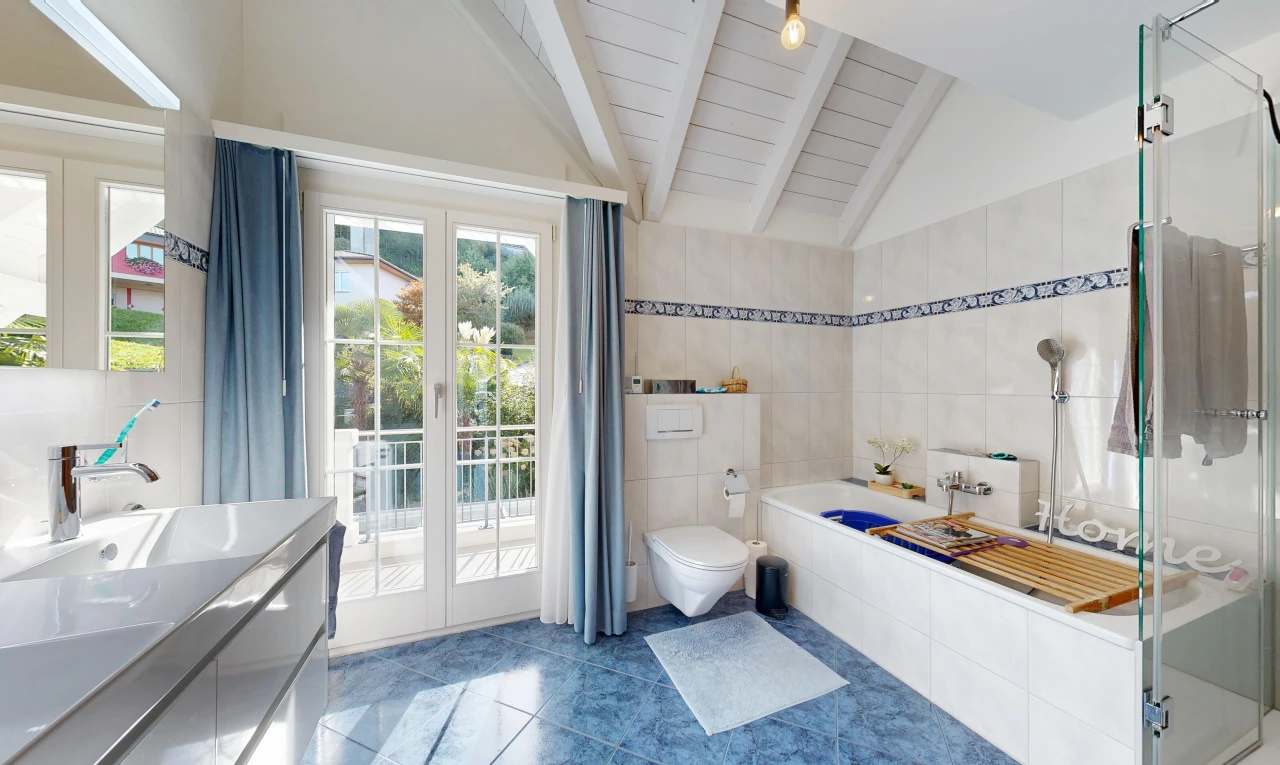 full bathroom featuring vanity, tile walls, a shower stall, vaulted ceiling, and dark tile patterned floors