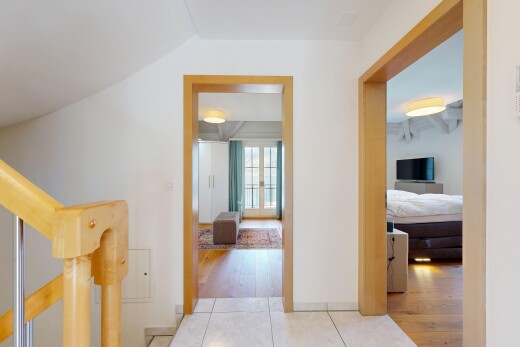 hallway featuring stairs and light tile patterned floors