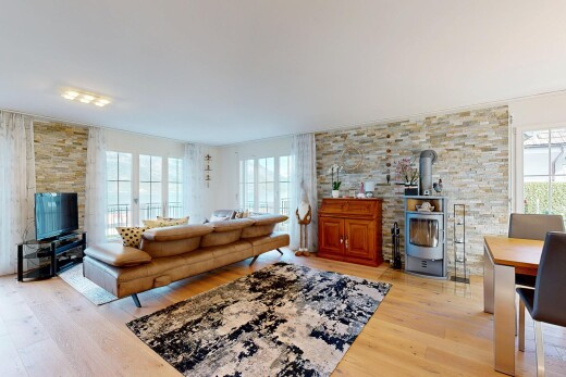 living area with a wood stove, light wood finished floors, and healthy amount of natural light