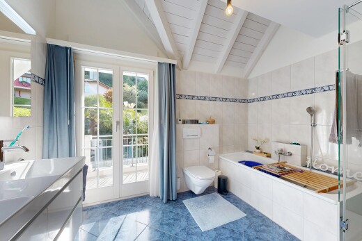full bathroom featuring vanity, tile walls, a shower stall, vaulted ceiling, and dark tile patterned floors