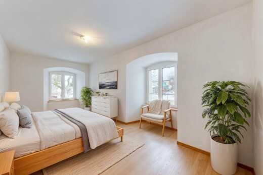 chambre avec plinthes murales, sol en finition bois, lumière naturelle, et cloison sèche