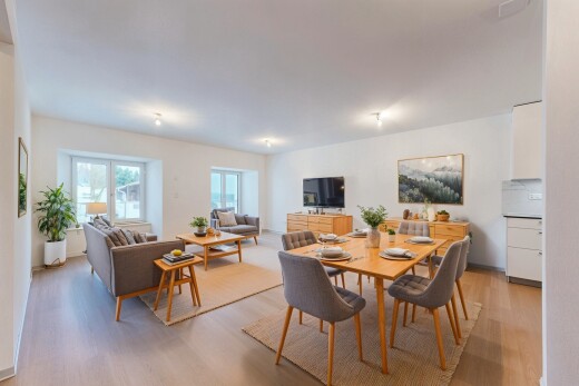 salon / salle à manger avec cloison sèche, télévision, lumière naturelle, et sol en finition bois