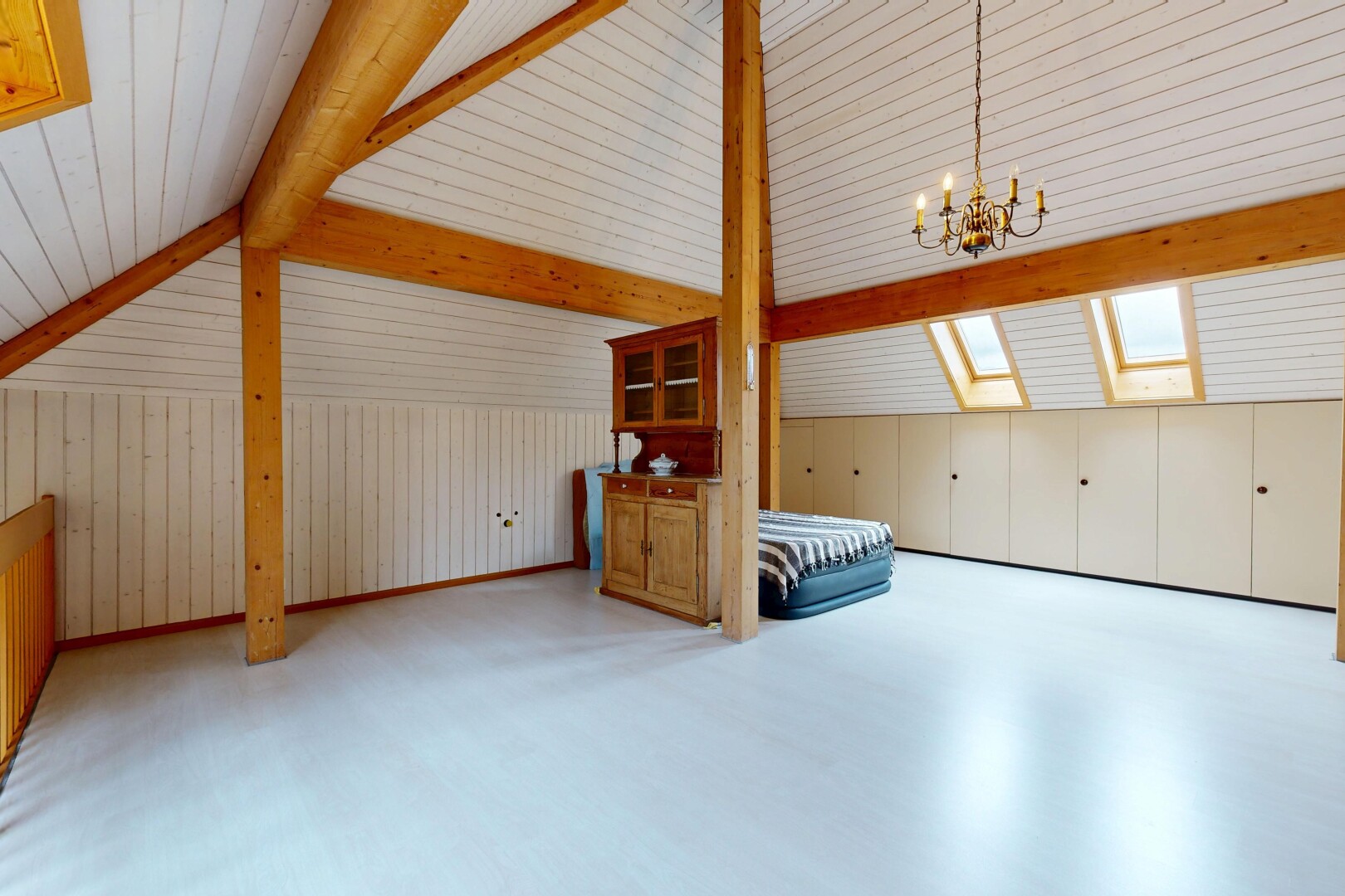 leerer raum mit light floor, bemerkenswerter kronleuchter, zusätzliches zimmer, inside property, und dachfenster