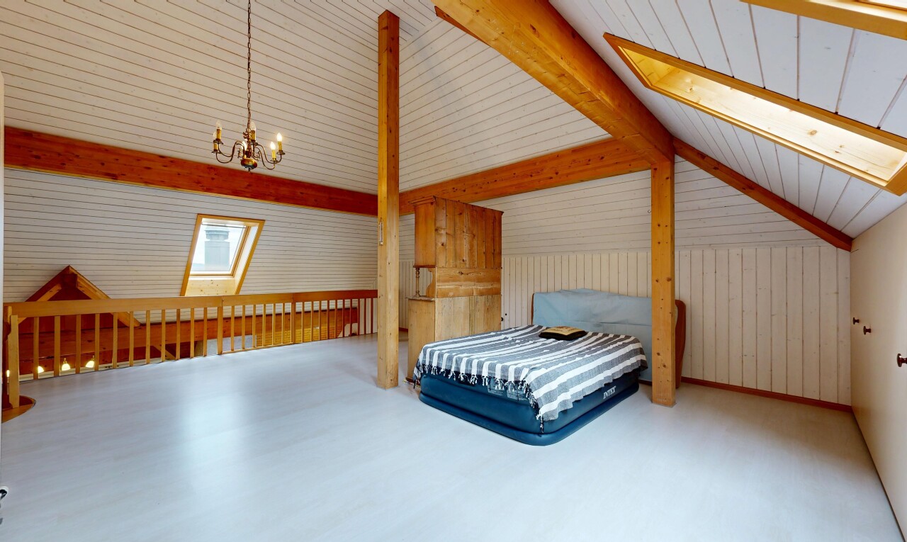 zimmer / schlafzimmer mit balkendecke, beamed ceiling, dachschräge, vaulted ceiling, und bemerkenswerter kronleuchter