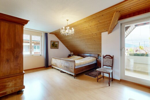 zimmer / schlafzimmer mit holzfußboden, wood finish floor, inside property, bemerkenswerter kronleuchter, und dachschräge