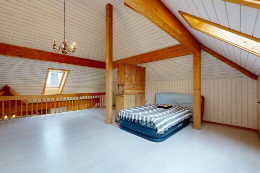 zimmer / schlafzimmer mit balkendecke, beamed ceiling, dachschräge, vaulted ceiling, und bemerkenswerter kronleuchter