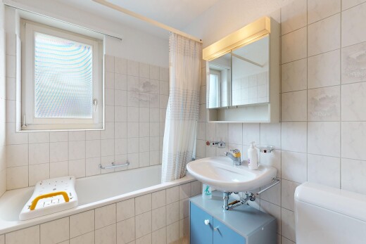 bathroom with tiled shower / bath, tile walls, and plenty of natural light