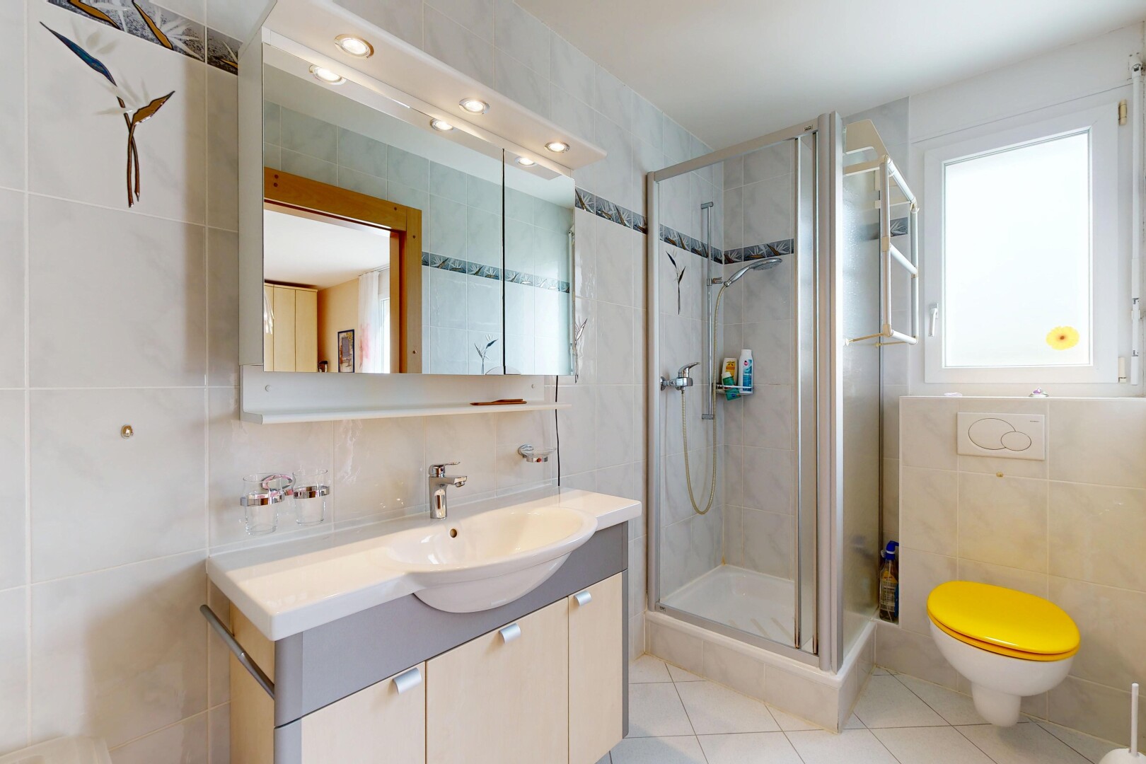 salle de bains avec tile wall, mur en carrelage, lavabo (ou coiffeuse selon le contexte), salle de bain complète, et douche