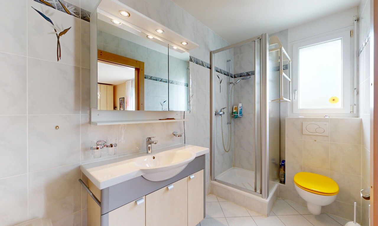 salle de bains avec tile wall, mur en carrelage, lavabo (ou coiffeuse selon le contexte), salle de bain complète, et douche
