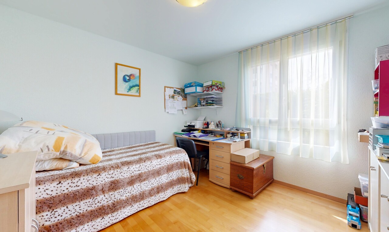 chambre avec wood finish floor, sol en finition bois, drywall, cloison sèche, et natural light