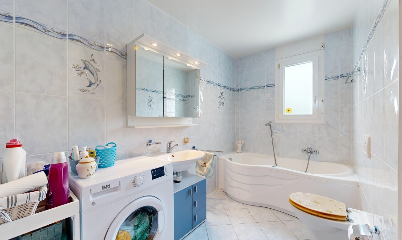 salle de bains avec mur en carrelage, tile wall, lave-linge et sèche-linge, salle de bain complète, et inside property