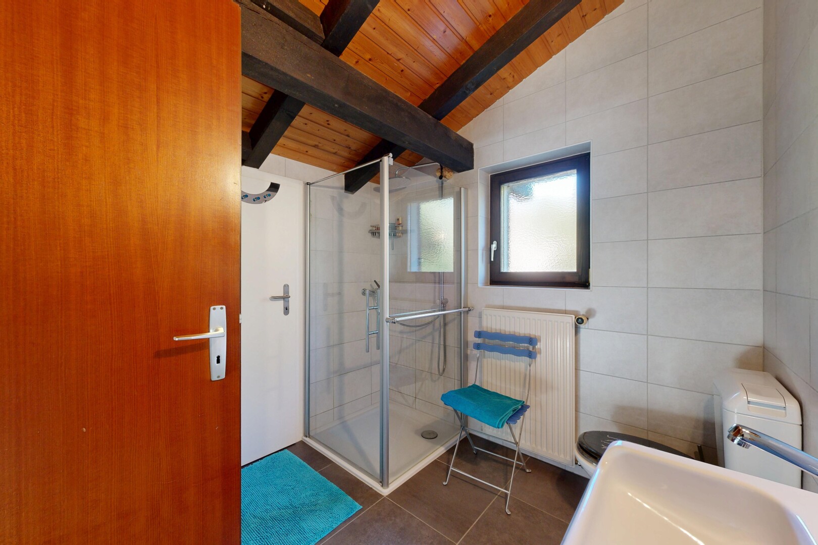 bathroom featuring radiator heating unit, a shower stall, wood ceiling, dark tile patterned floors, and tile walls