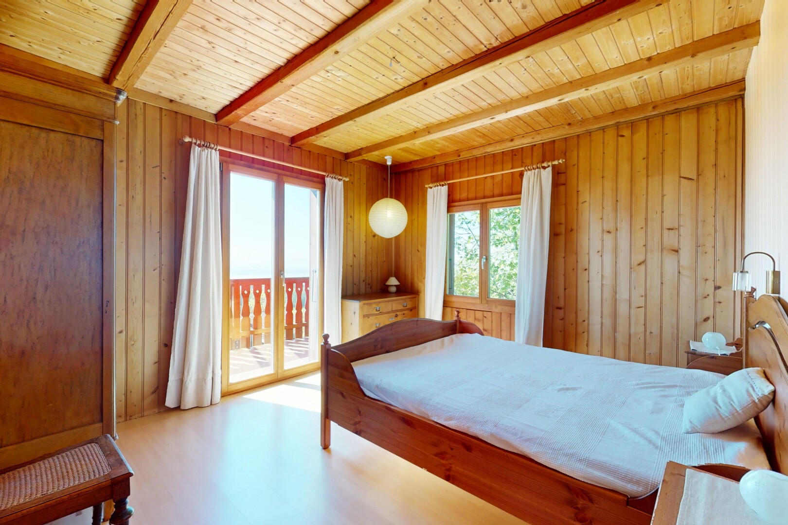 room / bedroom featuring access to outside, wooden walls, multiple windows, and beamed ceiling
