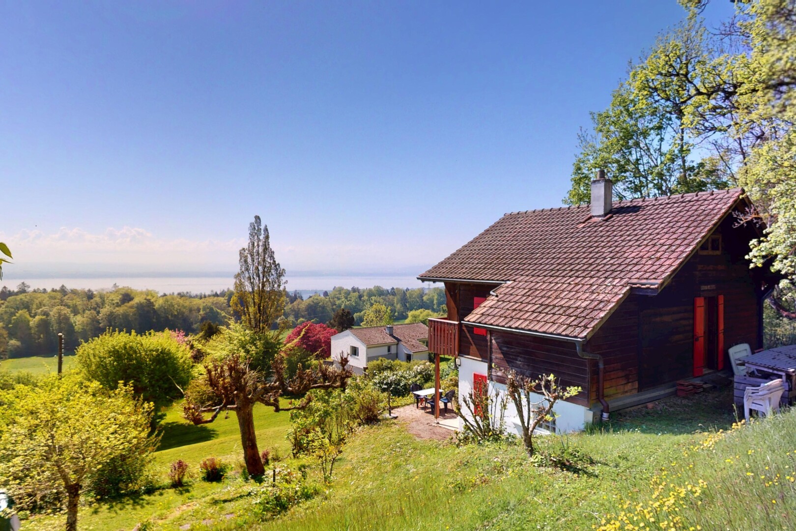 view of home featuring a yard, a tile roof, and a chimney