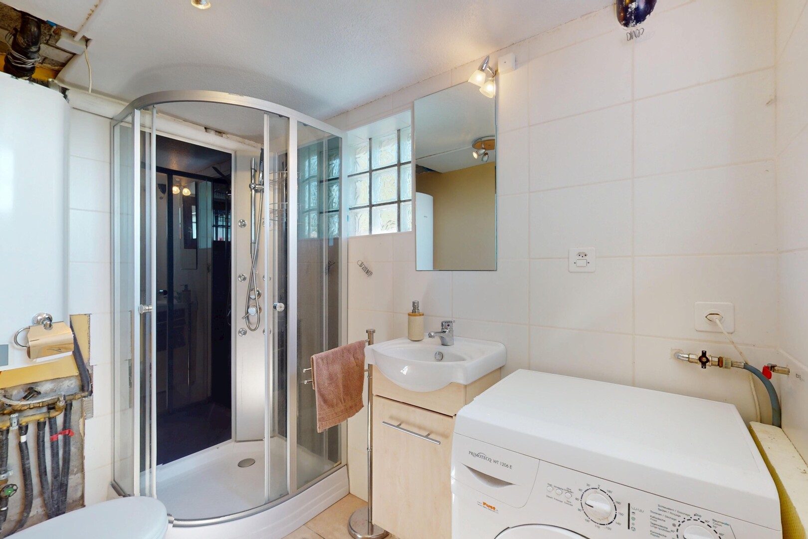full bath with washer / clothes dryer, tile walls, a shower stall, vanity, and toilet