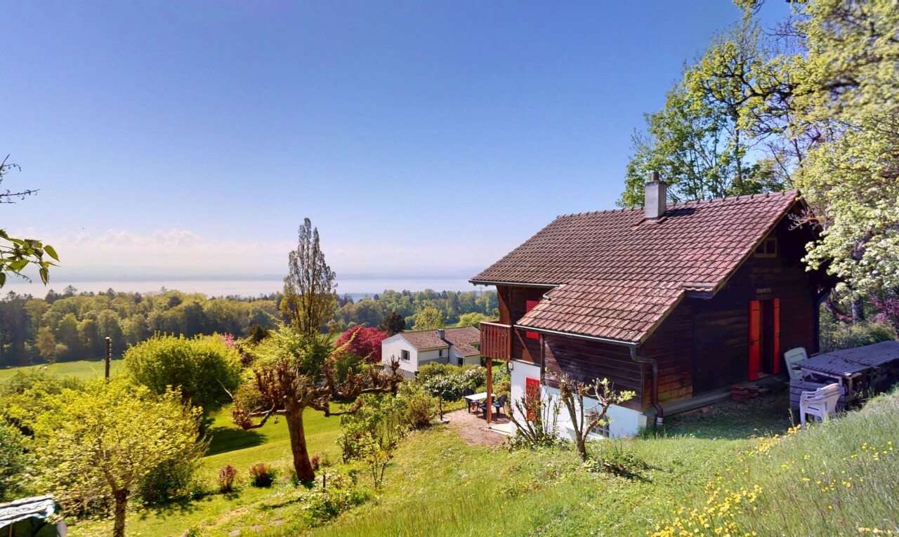 view of home featuring a yard, a tile roof, and a chimney