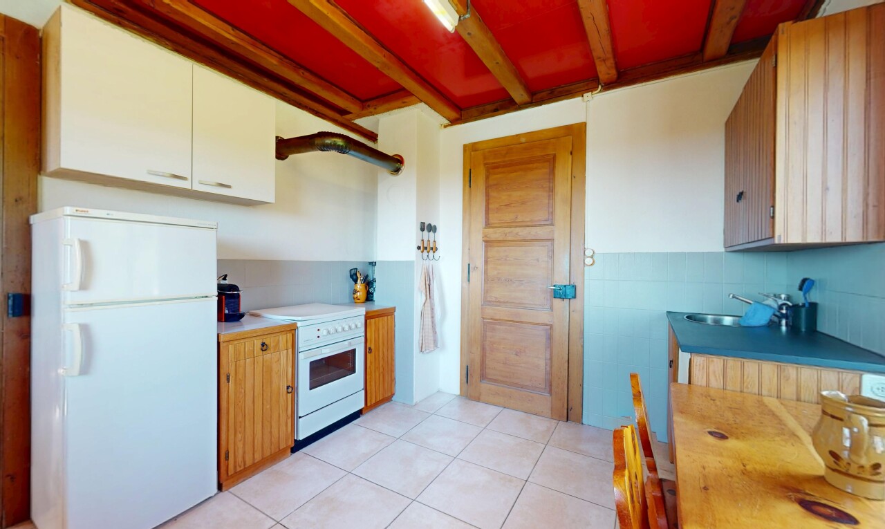 kitchen featuring a sink, light countertops, light tile patterned floors, beamed ceiling, and white appliances