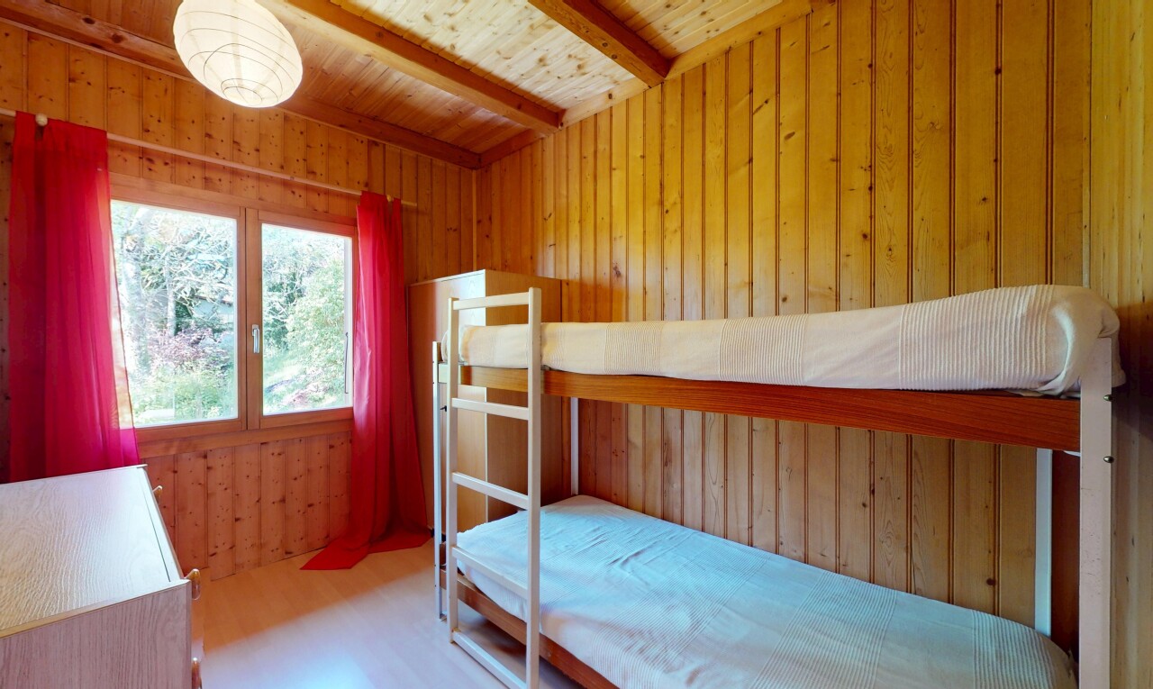 room / bedroom with wood walls, wood finished floors, beam ceiling, and wooden ceiling