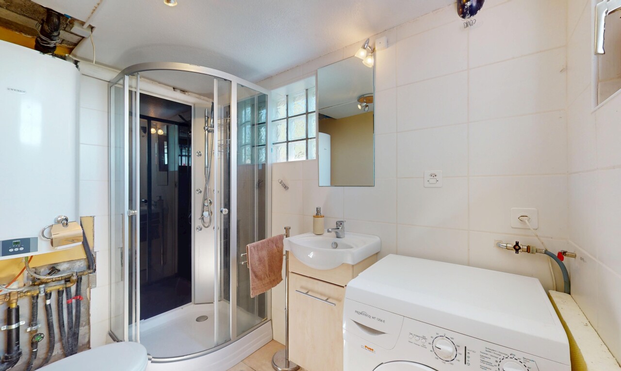 full bath with washer / clothes dryer, tile walls, a shower stall, vanity, and toilet