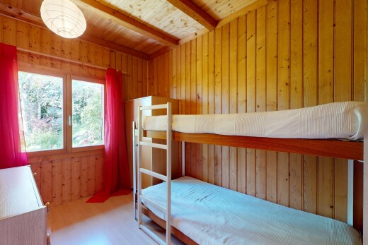 room / bedroom with wood walls, wood finished floors, beam ceiling, and wooden ceiling