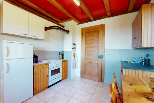 kitchen featuring a sink, light countertops, light tile patterned floors, beamed ceiling, and white appliances