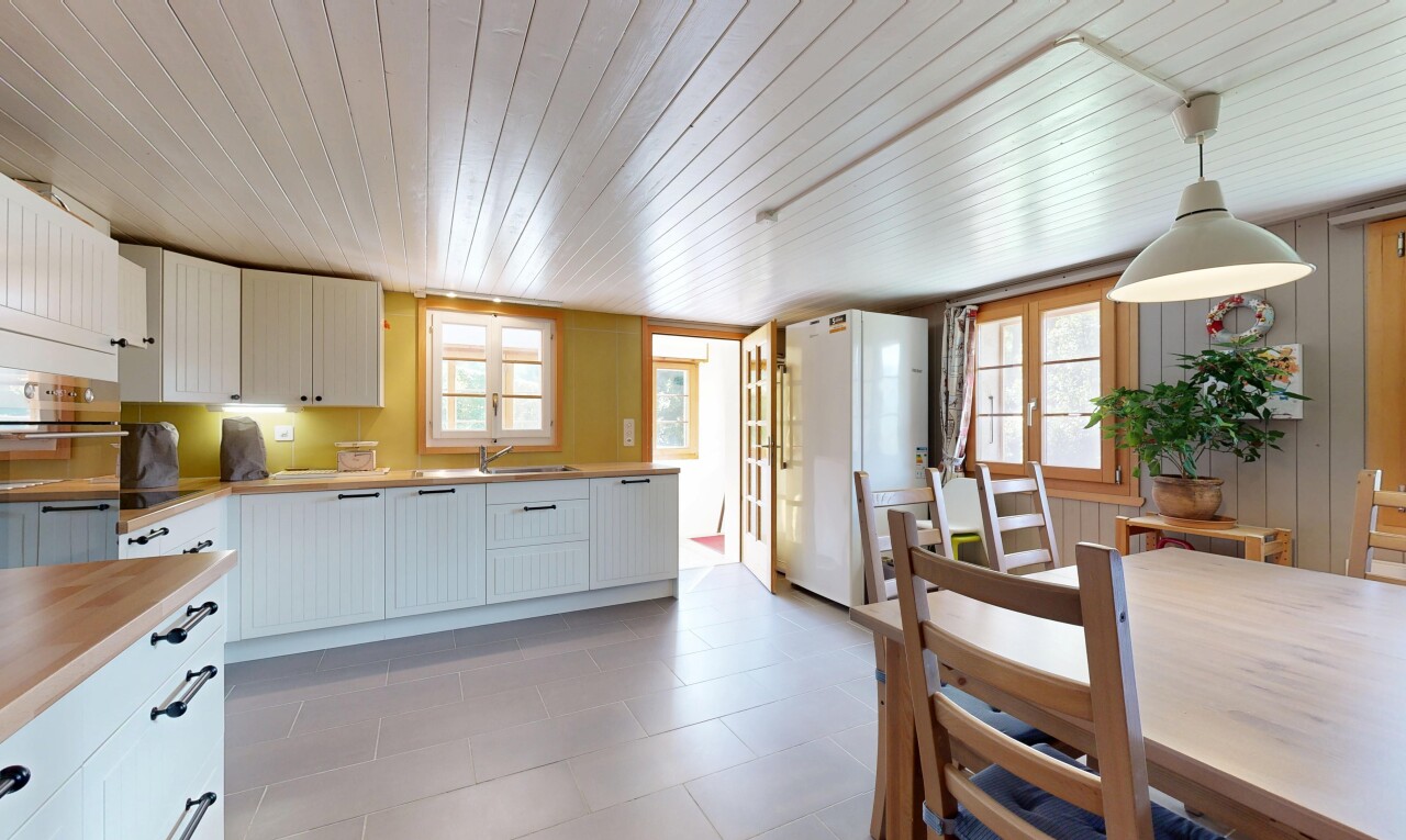 cuisine avec armoires blanches, réfrigérateur, éclairage suspendu, plans de travail, et inside property