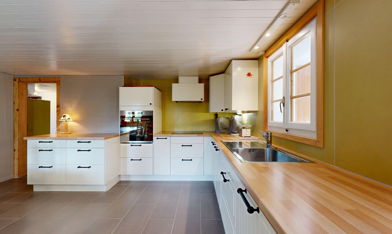 cuisine avec inside property, natural light, lumière naturelle, armoires blanches, et four