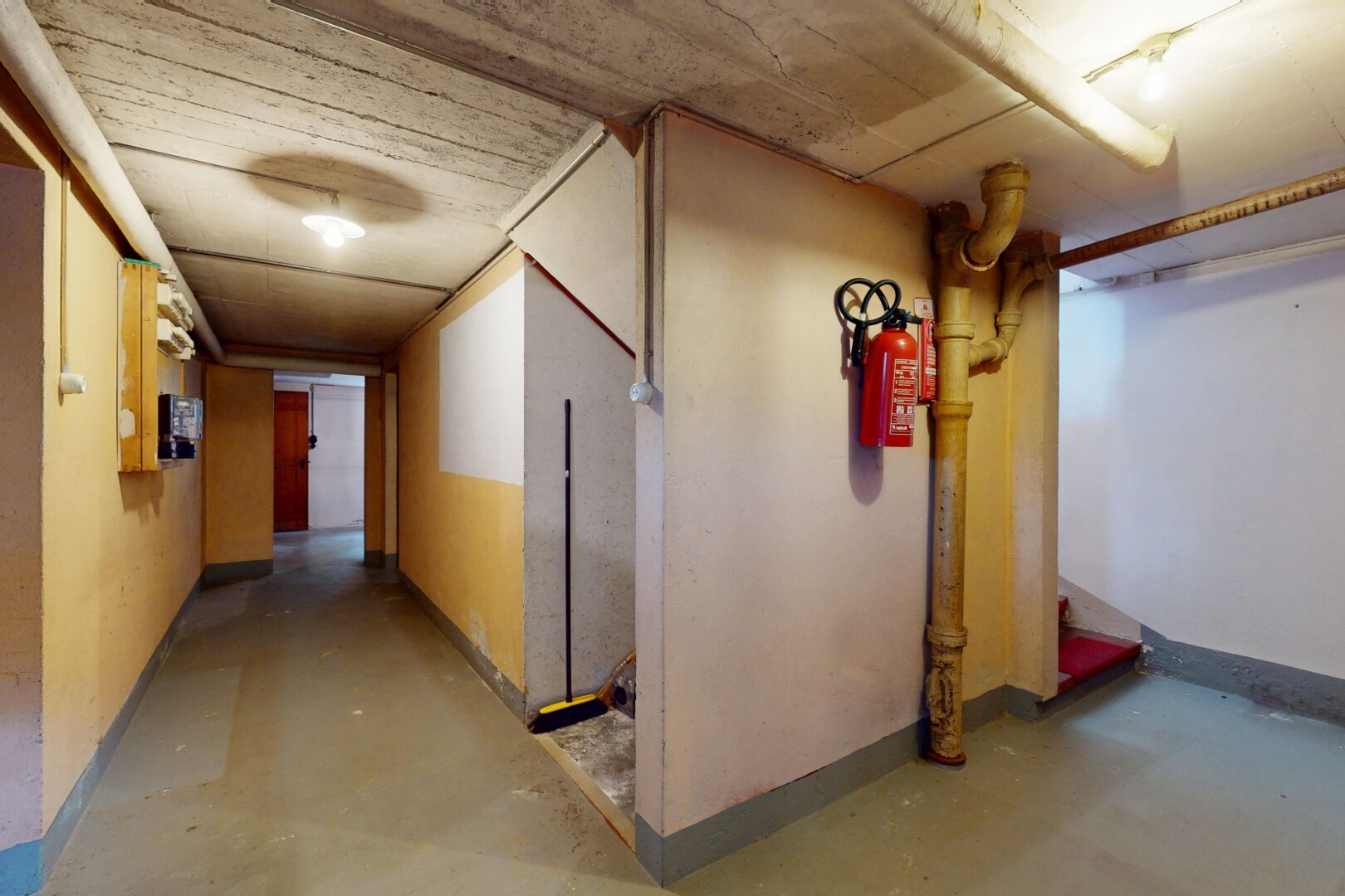 couloir avec inside property, concrete floor, sol en béton, baseboards wall, et plinthes murales