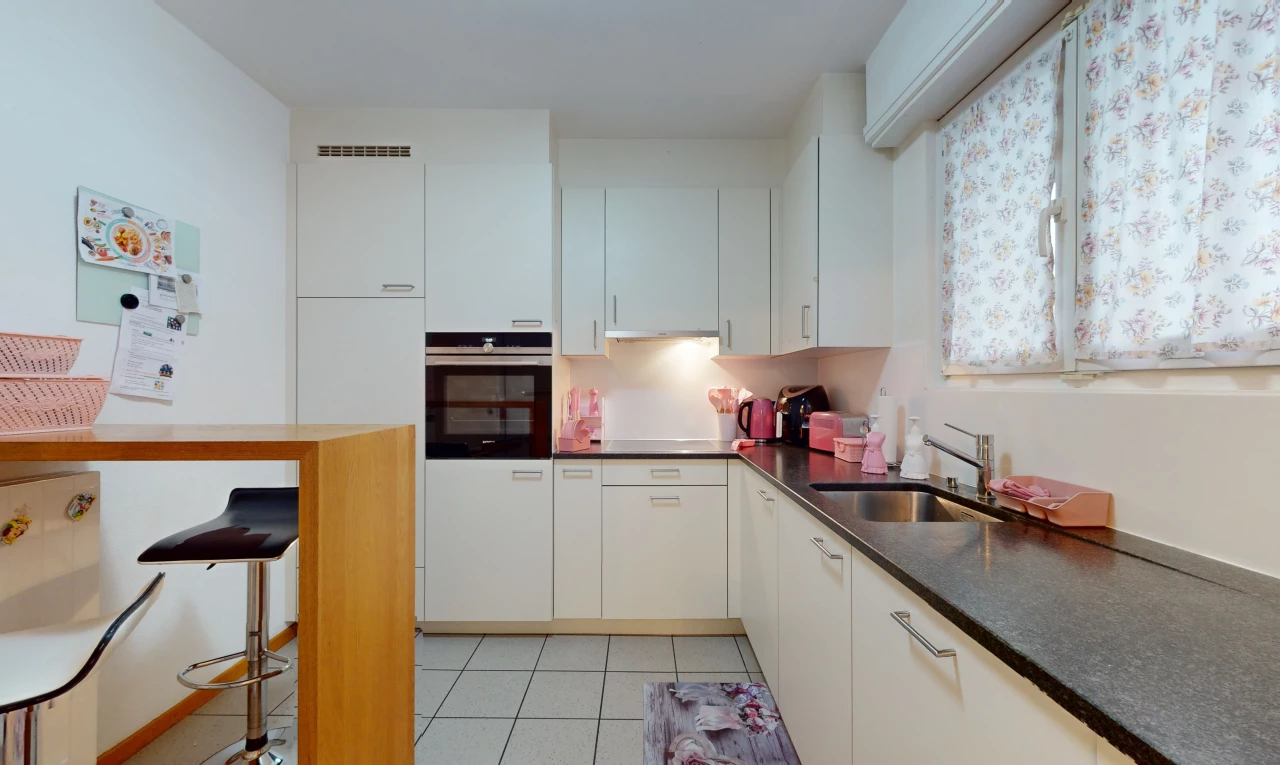 küche mit waschbecken, hellen fliesenböden, ofen und weissen schränken