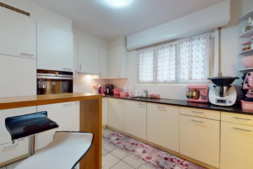 küche mit hellen fliesenböden und edelstahlofen