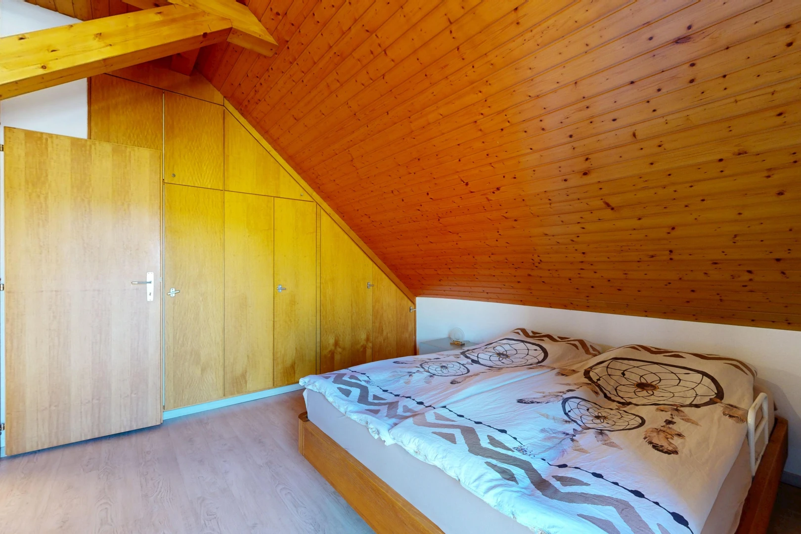 chambre avec vaulted ceiling, plafond voûté, wood finish floor, sol en finition bois, et wood ceiling