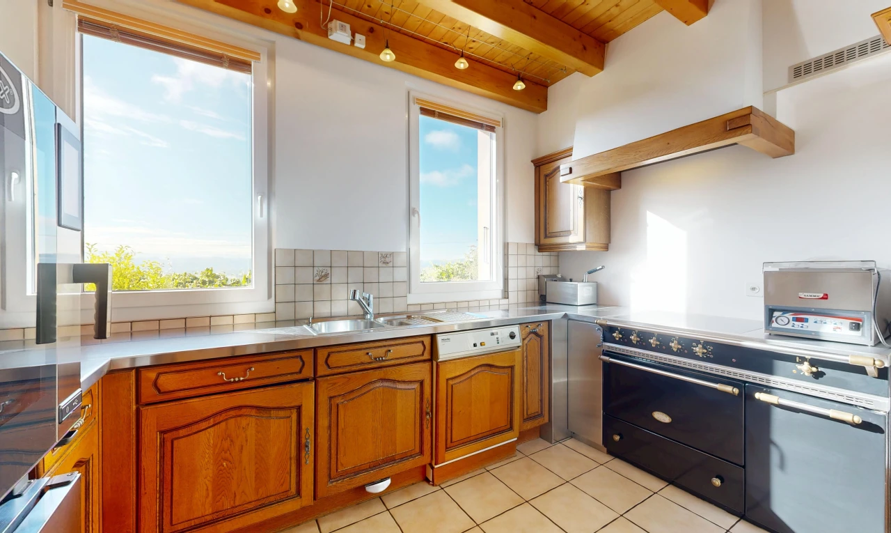 cuisine avec stainless steel countertops, plans de travail en acier inoxydable, éclairage sur rail, cuisinière, et raised cabinets