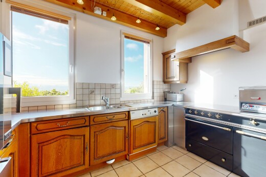 cuisine avec stainless steel countertops, plans de travail en acier inoxydable, éclairage sur rail, cuisinière, et raised cabinets