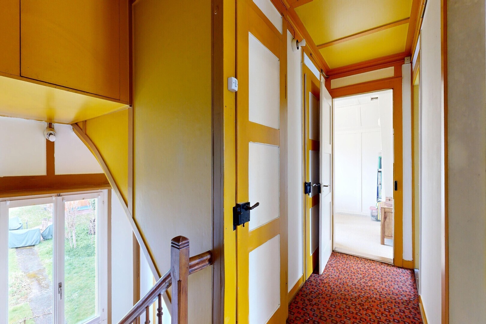 hall featuring dark carpet and an upstairs landing