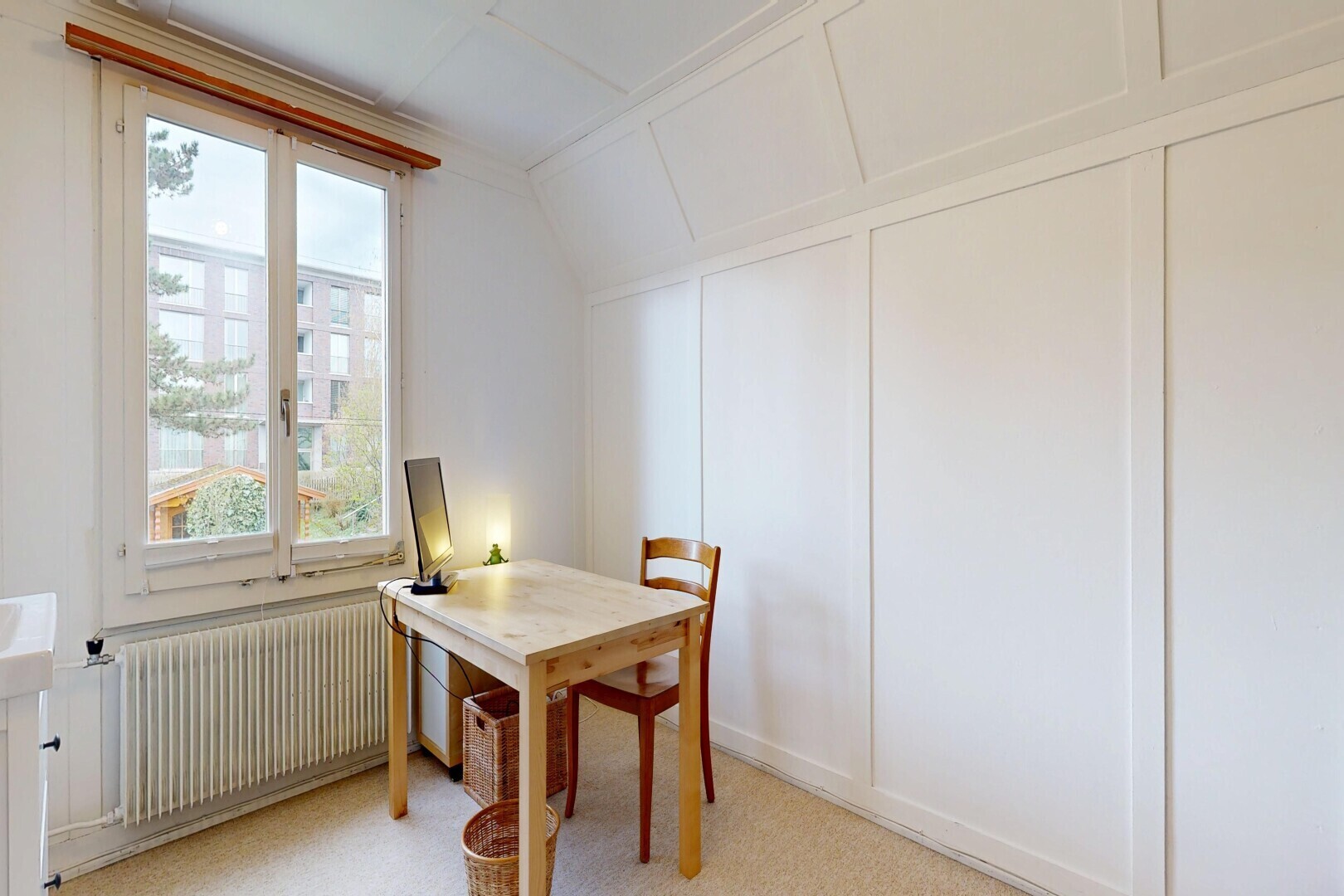 dining space featuring radiator, a decorative wall, light colored carpet, a desk, and vaulted ceiling