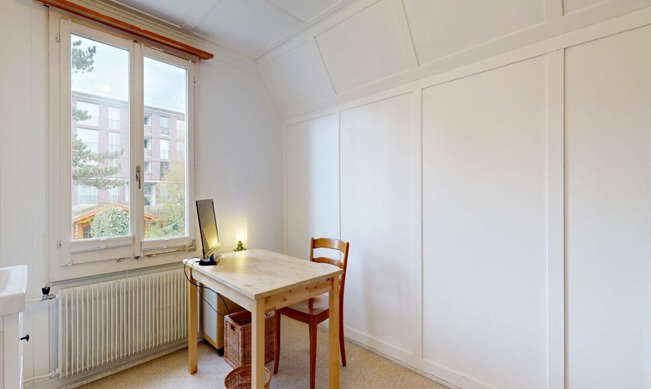 dining space featuring radiator, a decorative wall, light colored carpet, a desk, and vaulted ceiling