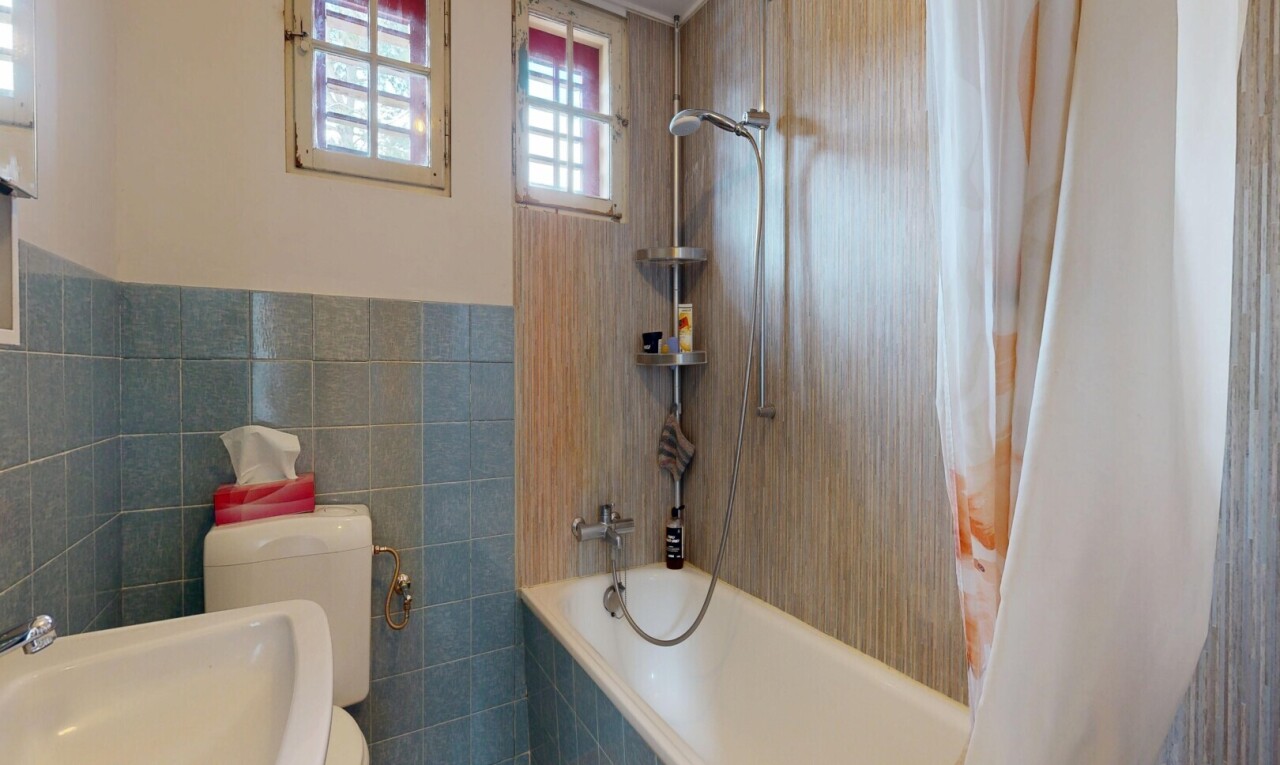 full bathroom with tiled shower / bath and tile walls